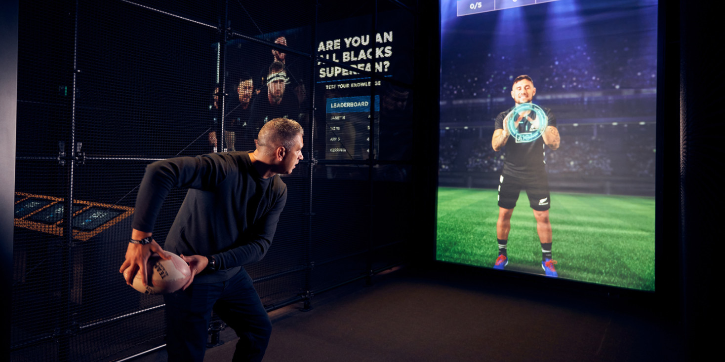 Man passing rugby ball towards digital screen target 