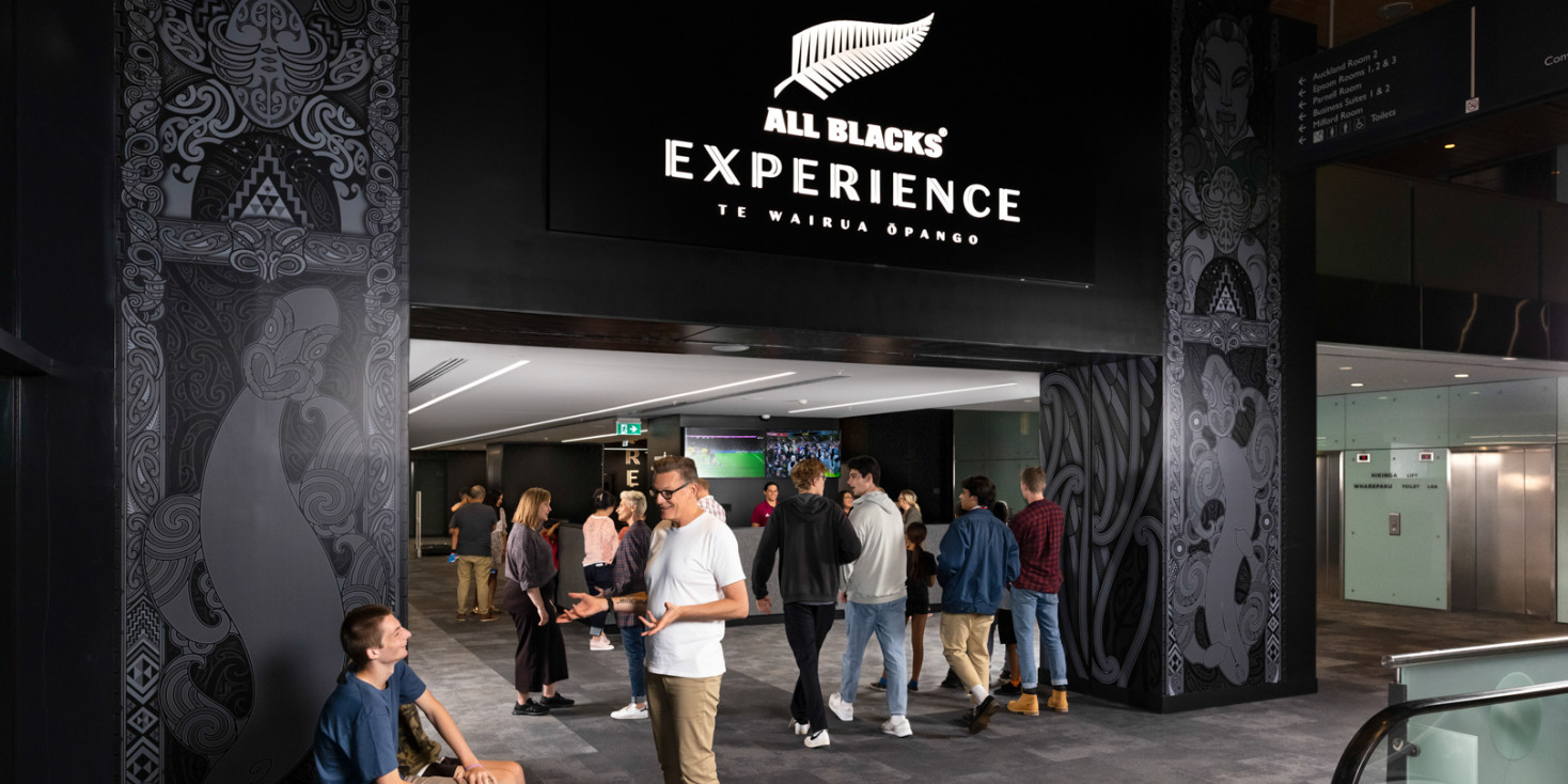 Man standing in front of the entrance to the All Blacks Experience 