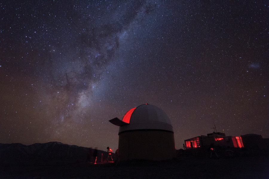 View of milky way with observatory in foreground at top of Mt John