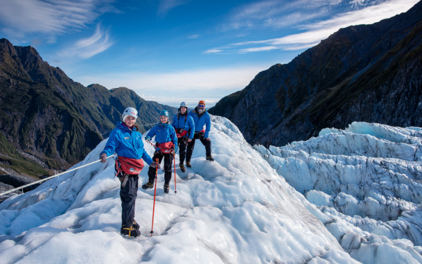 Group of people standing on glacier with view down the valley
